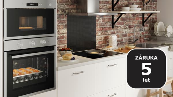 bílá kuchyně od IKEA se stříbrnou digestoří a dvěma vestavnými troubami MATÄLSKARE