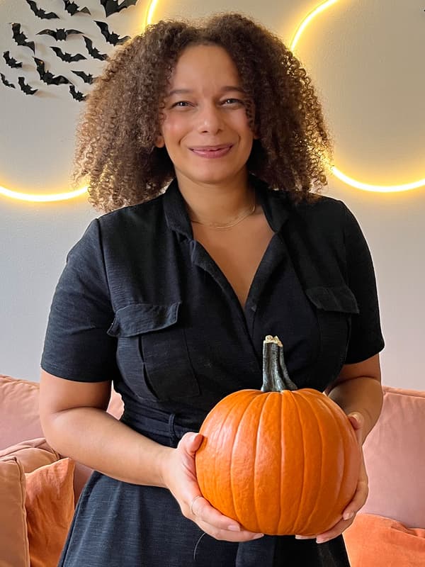 Bild på en halloweenintresserad IKEA medarbetare som håller i en stor pumpa.
