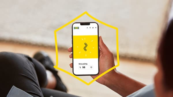 Bild på en person som håller en mobil i handen som visar hur många poäng som samlats.