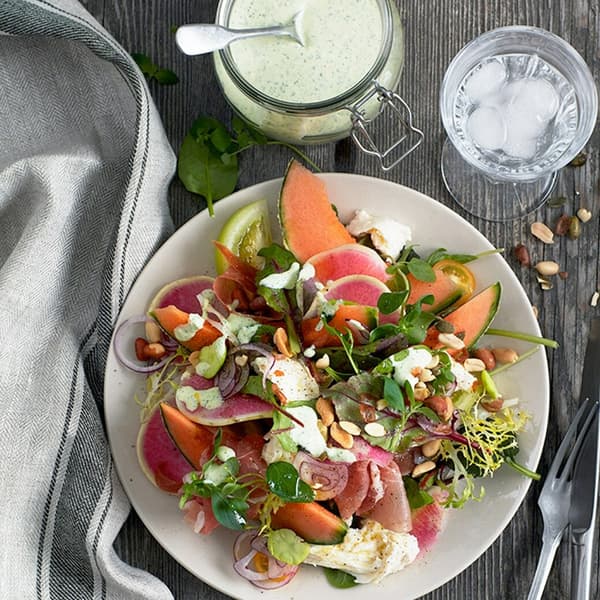 Bild tagen uppifrån på en somrig sallad i en vit skål.