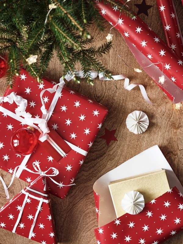 Bild tagen uppifrån på julklappar som slås in i rött presentpapper.