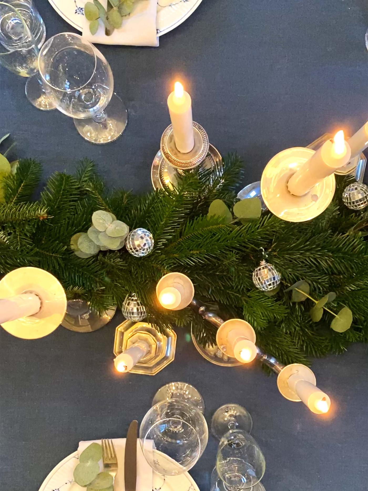 Bildet er tatt over stearinlysene på bordet, for en fin effekt. Vi ser girlanderet og lysene.