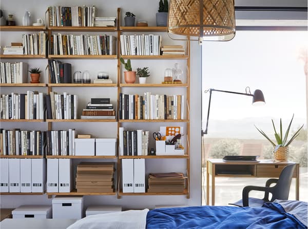 Bilik tidur dengan kombinasi para lekap dinding besar yang dibuat daripada buluh digunakan untuk meletakkan buku, tumbuh-tumbuhan dan item hiasan.