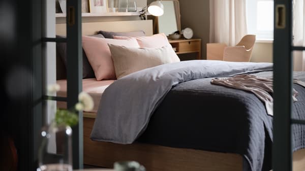 Bilik tidur yang mempunyai katil otoman MALM, linen katil KOPPARBLAD, meja solek NORDKISA dan kerusi persidangan FJÄLLBERGET.