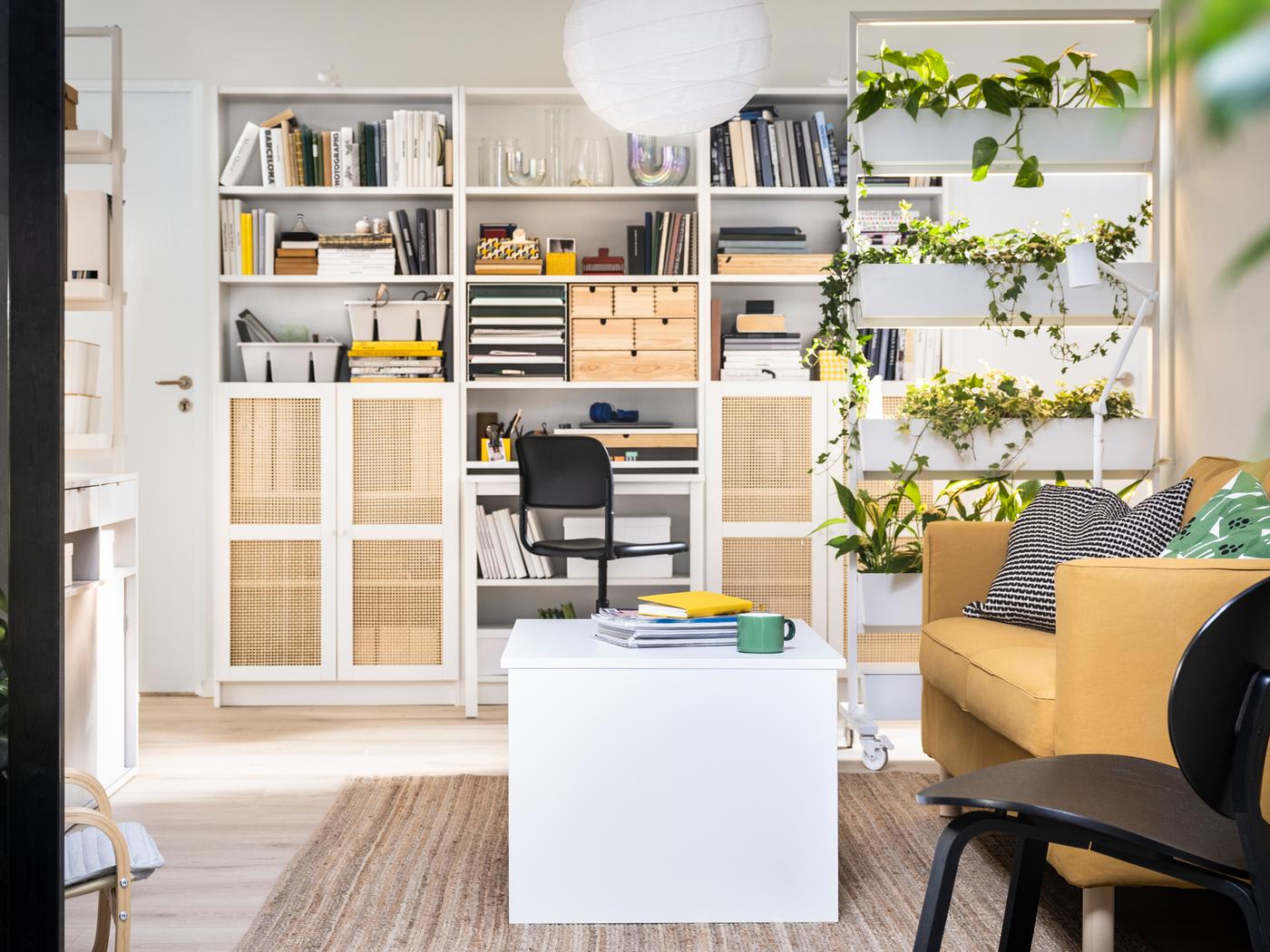 BILLY boekenkasten tegen een muur, achter een MITTZON frame op wielen, een ÖSTAVALL verstelbare salontafel en een zitbank.