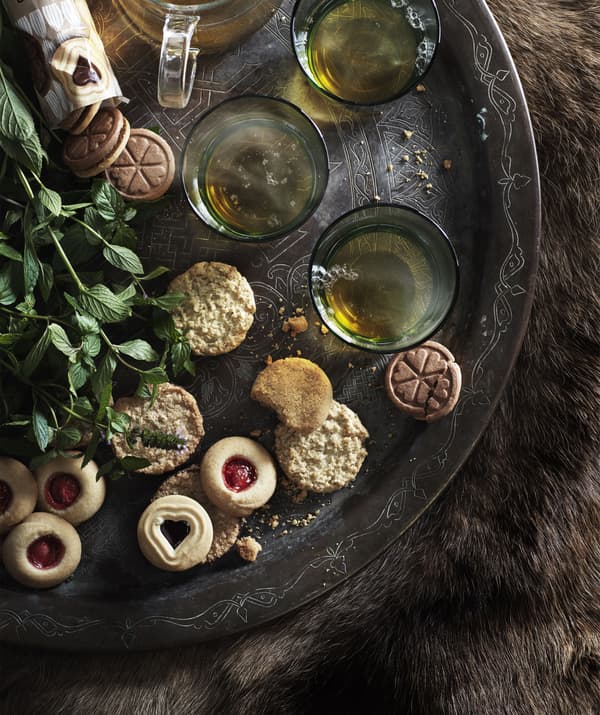 Biscuits et tasses de thé disposés sur un grand plateau.
