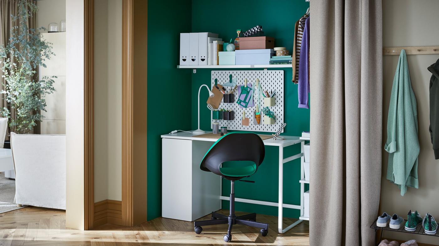 Biurko LÄRANDE i krzesło obrotowe ELDBERGET/MALSKÄR stoją w szafie. Tablice perforowana SKÅDIS wisi na ścianie, a na niej znajdują się przybory biurowe.