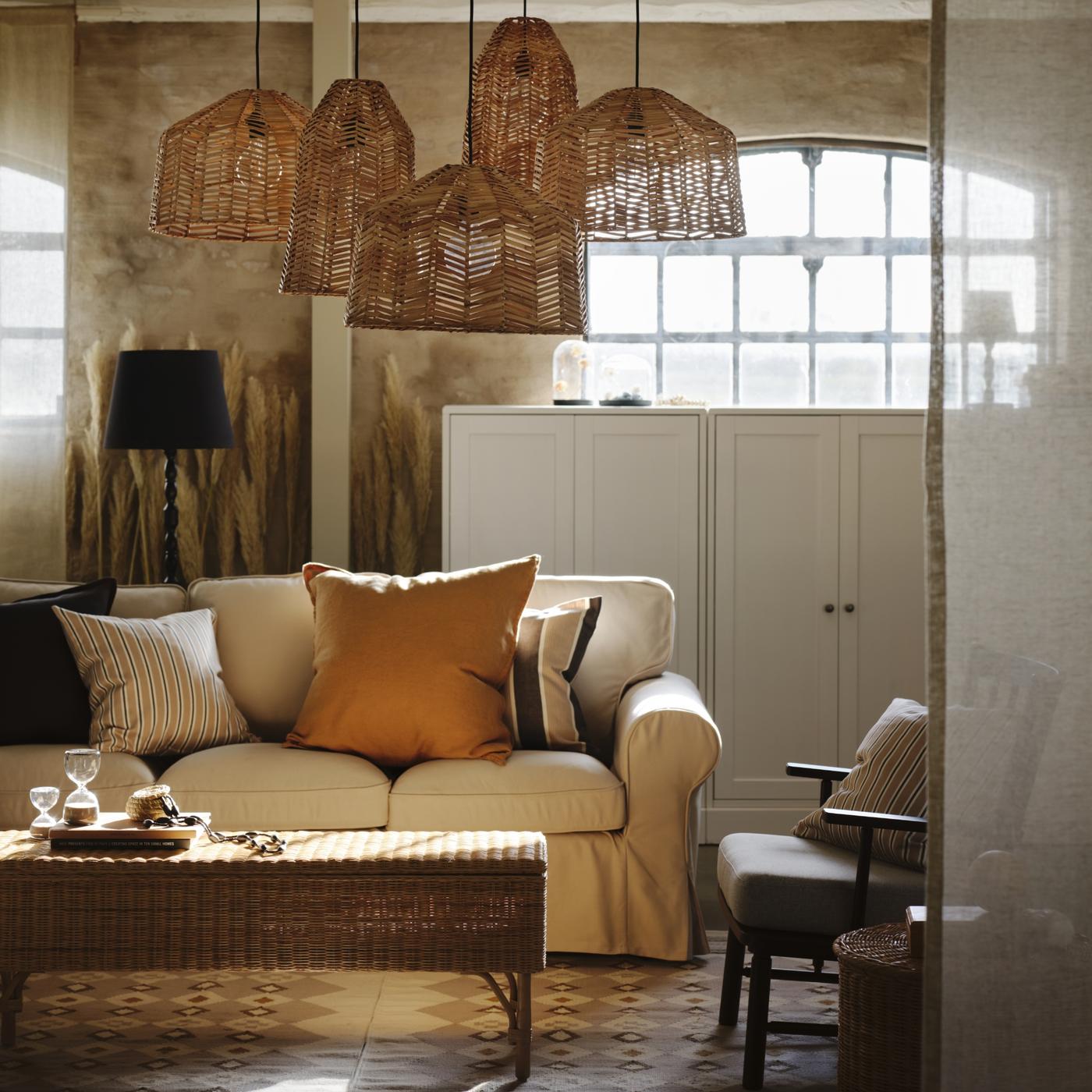 ベージュの背景の前に、クッションやランプなどの小物類でつくられたコラージュ。