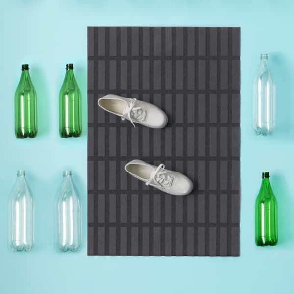 black and grey SIVESTED doormat in front of a white door.