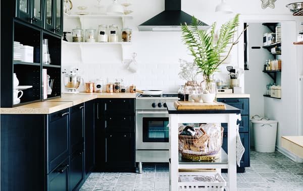 Black and white kitchen with pantry area packed with storage solutions.