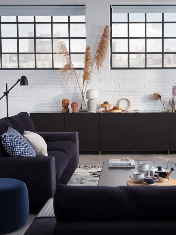 Black BESTÅ cabinets behind a sofa