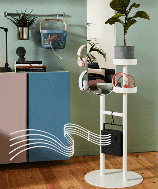 Black ENEBY bluetooth speaker suspended from a LIERSKOGEN valet, overlaid with an animation of musical notes appearing on a staff.