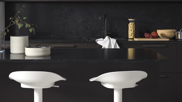 Black kitchen worktop with white chairs
