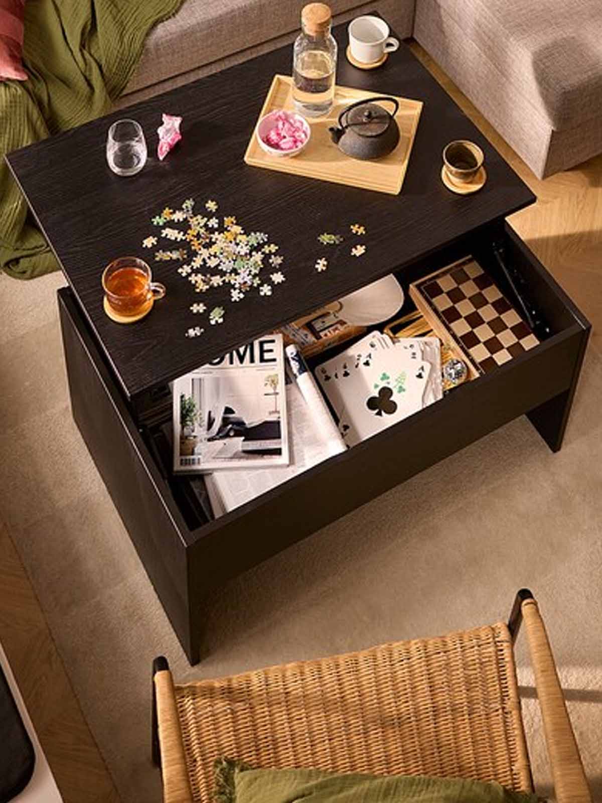 Black OSTAVALL coffee table in the living room, with the top exposed to show the storage space within the coffee table.