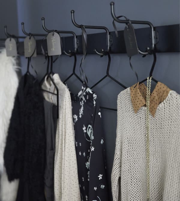 Black PINNING rack with hooks holds outfits selected for the coming days.