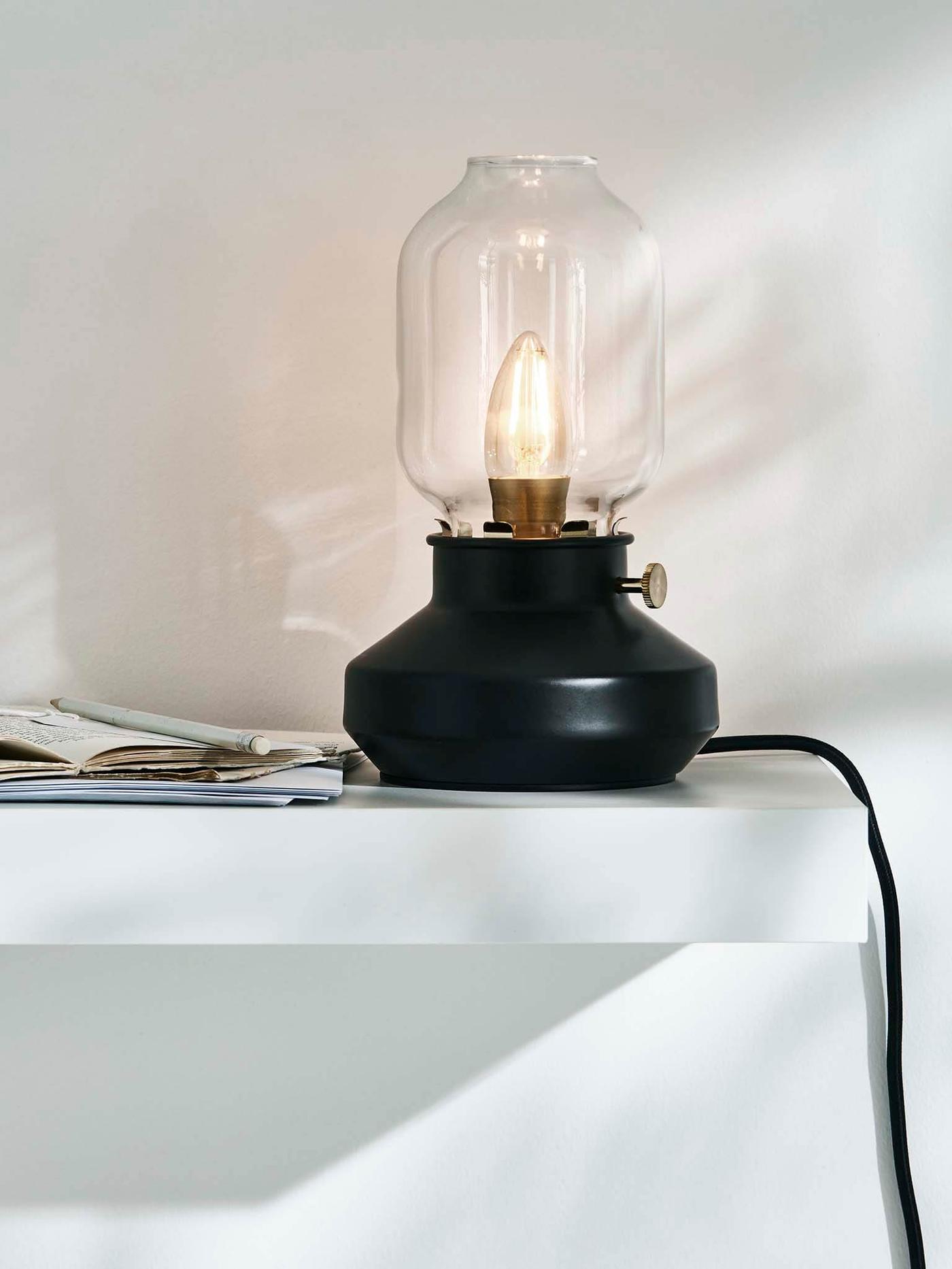 Black TÄRNABY table lamp sitting on a white shelf.