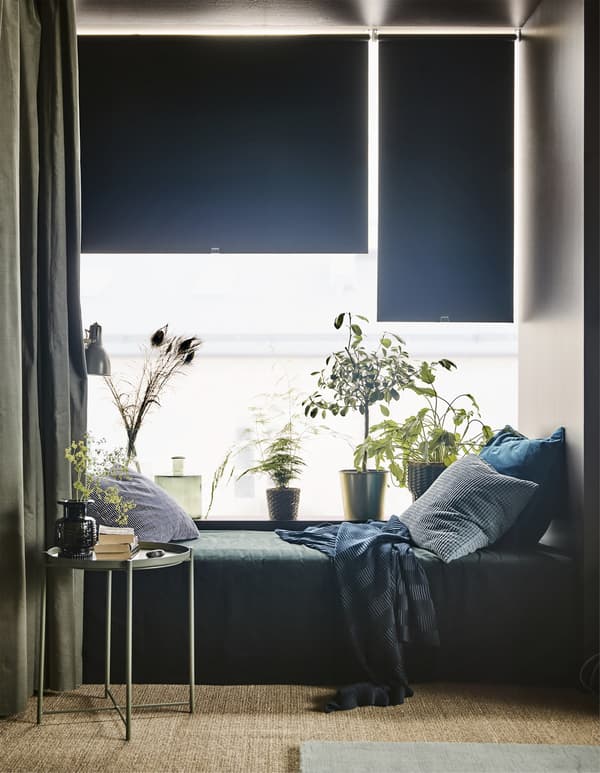 Blackout blinds pulled partly down over living room windows.