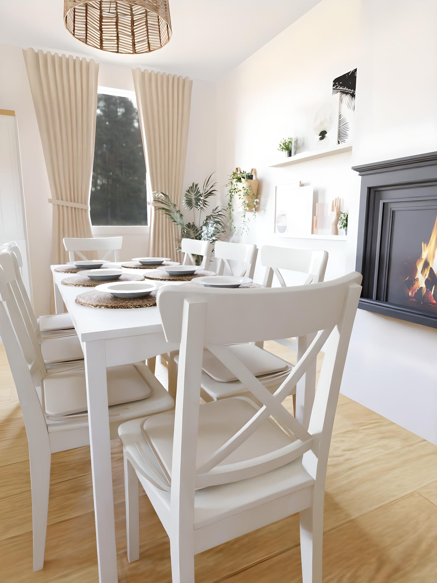 Blagovaonica s bijelim stolom i stolicama, postavljenim tanjurima, zavjesama na prozorima i kaminom s desne strane.