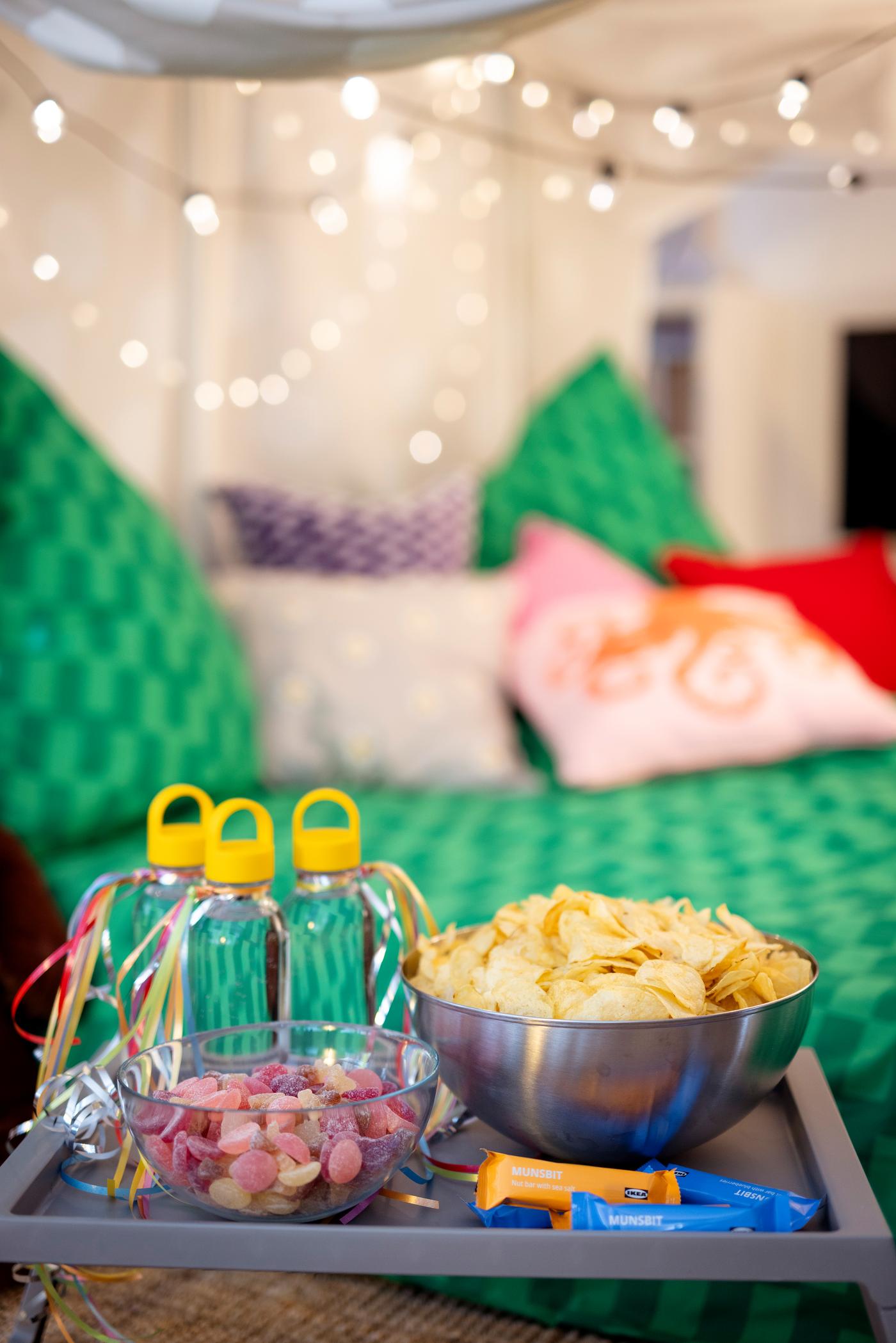 Blick auf die Snacks. Jeder Gast bekommt seine eigene Mehrwegflasche mit Schraubverschluss. Auf einem Serviertablett sind Snacks angerichtet. 