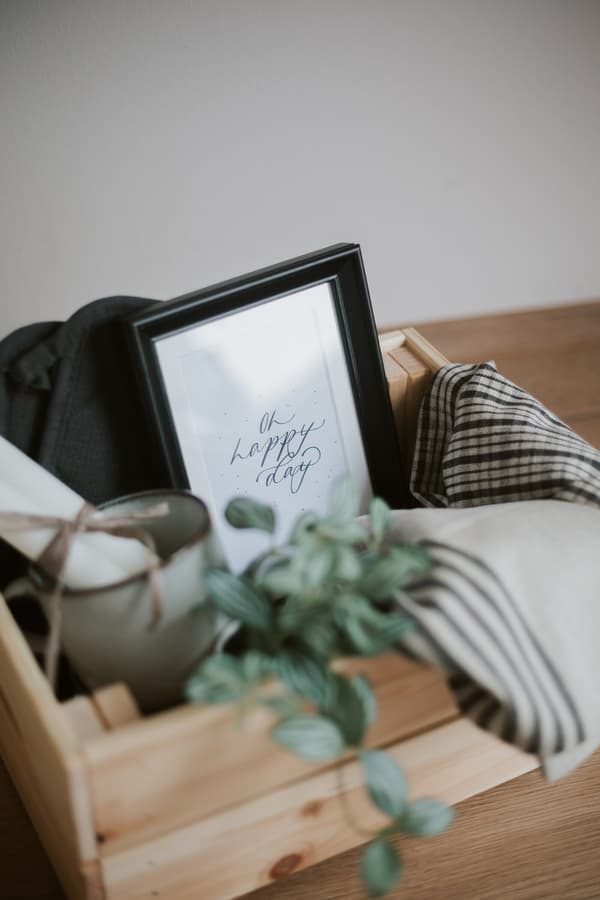 Blick in den Geschenkkorb mit Geschirrtuch, Bilderrahmen und Pflanze.