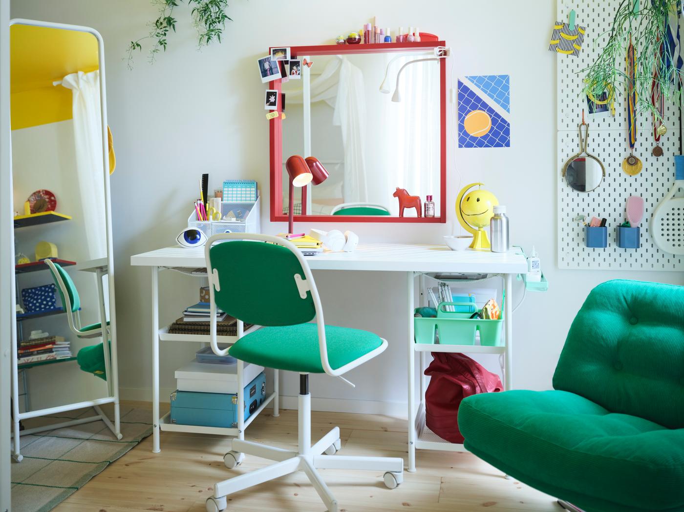 Blick in ein Kinderzimmer: ein weißer Schreibtisch dazu ein grüner Schreibtischsessel. Ein roter Spiegel