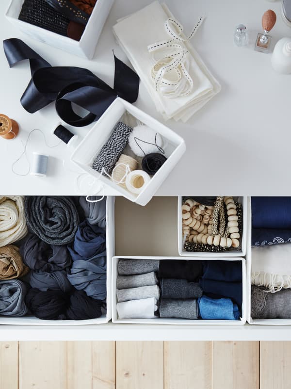 Blick von oben auf eine Kommode mit geöffneten Schubladen, in denen Socken und Co. in SKUBB Boxen geordnet sind.