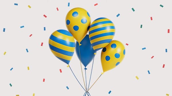 Blue and yellow balloons with confetti falling