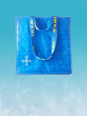 Blue FRAKTA cooling bag against an icy blue background, to show its cooling qualities.