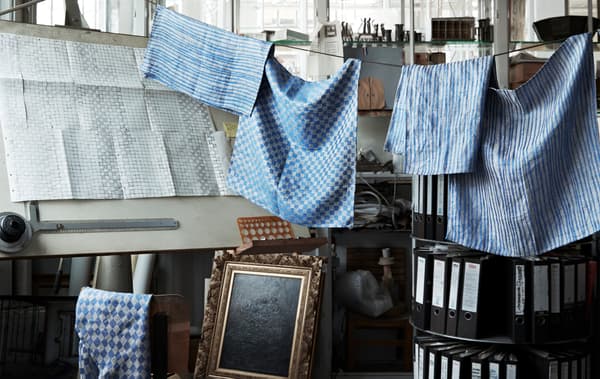 Blue patterned linen hanging on a line in a workshop.