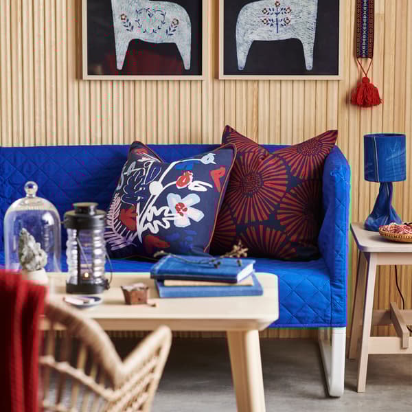 Blue sofa with folk-style flower cushions
