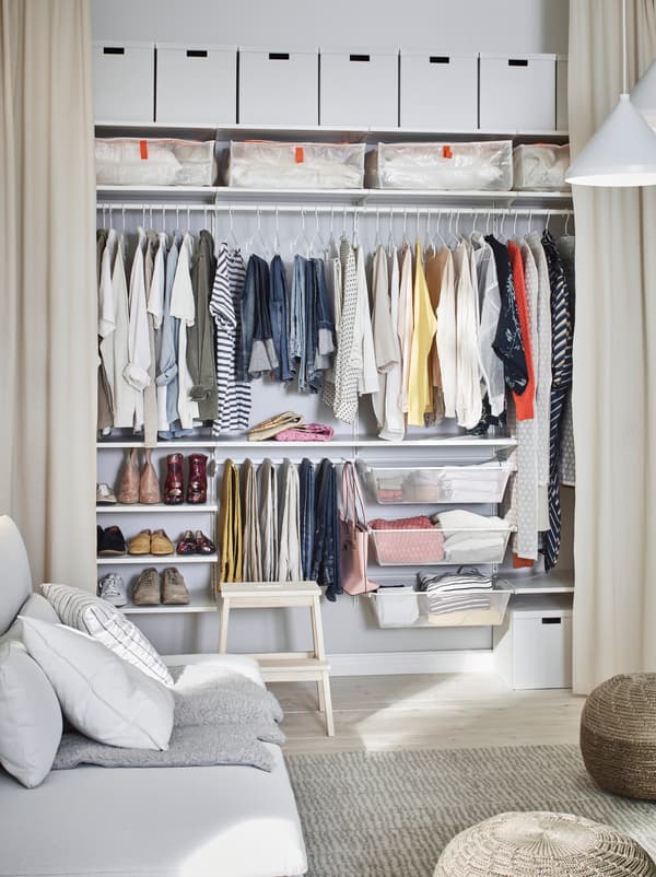 ห้องที่ผนังด้านหนึ่งมีม่านยาวถึงพื้น ผ้าม่านเปิดให้เห็นการจัดตู้เสื้อผ้า BOAXEL ที่กว้างเท่าผนัง