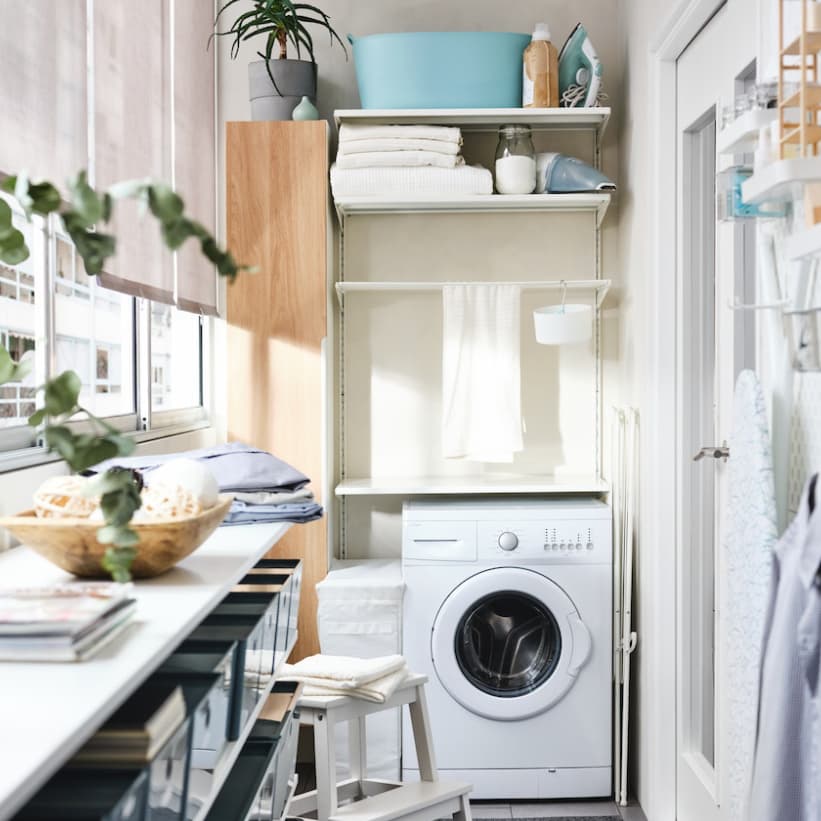BOAXEL wall mounted open shelf system in laundry area with washing machine and other shelvings for laundry use.