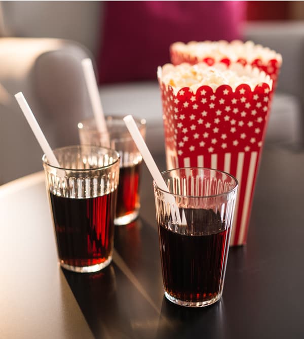 Boisson et popcorn sur une table basse.