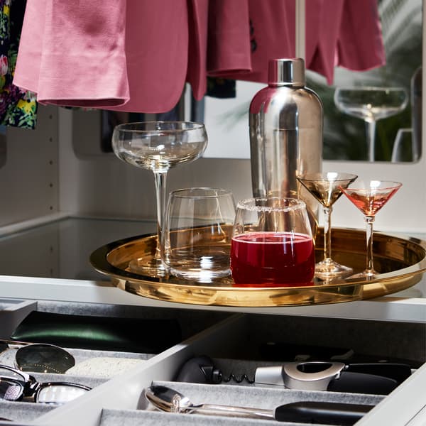 Boissons présentées sur un plateau rond IKEA GLATTIS couleur laiton aux bords surélevés.