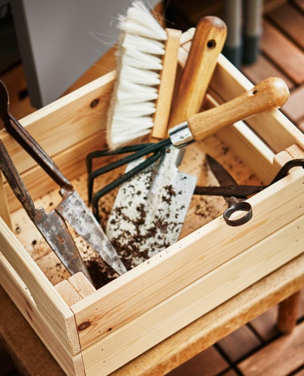 Boîte en bois remplie d’outils de jardinage.