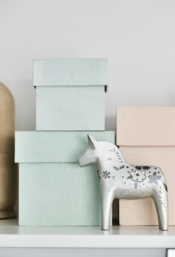 Boîtes de rangement pastel empilées sur une tablette.