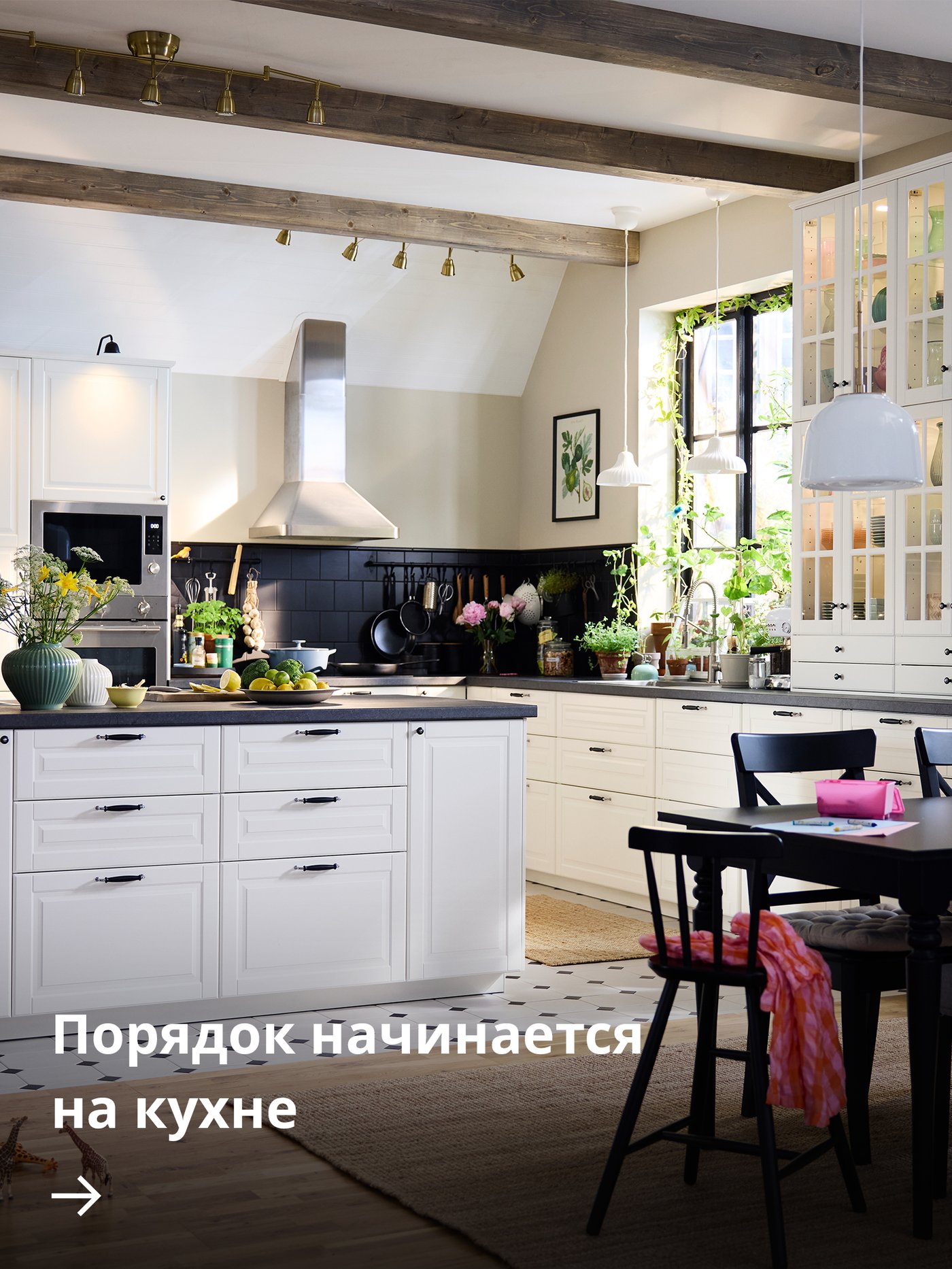 Большая кухня в традиционном стиле с белыми фасадами BODBYN, с кухонным островом и обеденной группой из тёмного дерева.