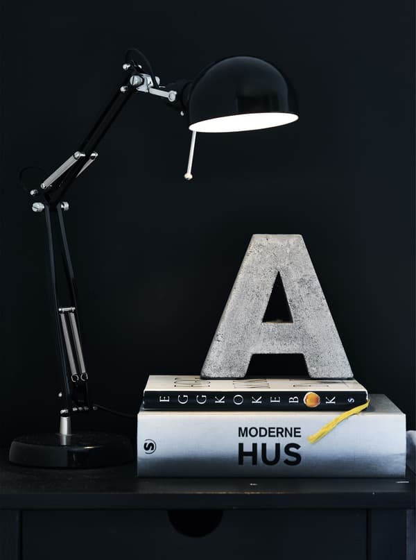 Books and a lamp on a bedside table.