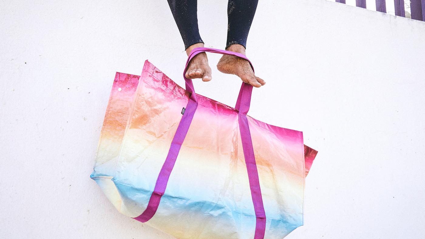 borsa -kaseberga-con-sfumature-blu-gialle-e-rosa-ai-piedi-di--f87328285a49c51bd5a8c7efa93f2194.jpg