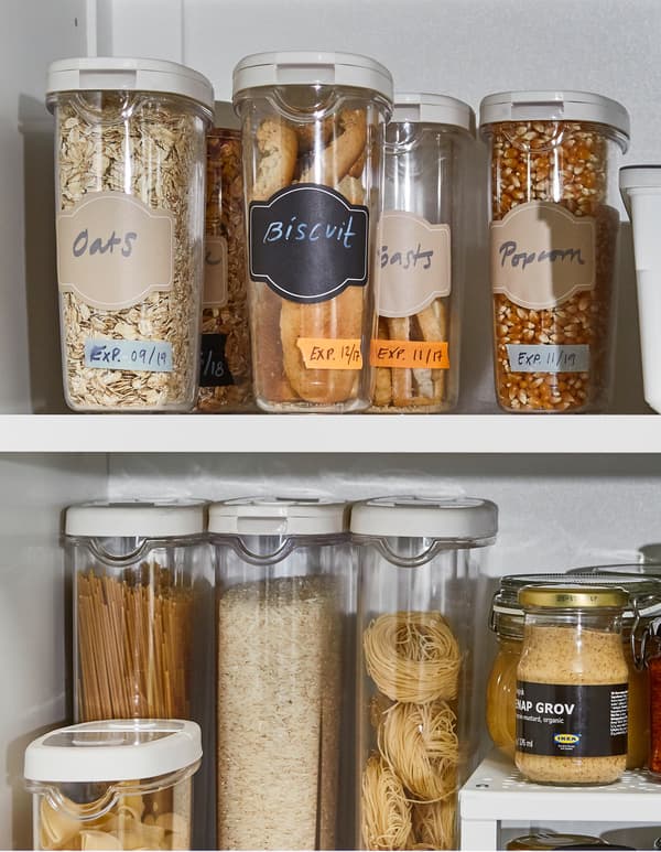 Botes IKEA 365+ para comida deshidratada con avea, galletas e cereais, dentro dun armario de cociña branco.