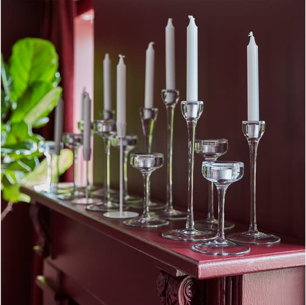 Bougeoirs BLOMSTER en verre posés sur le manteau de la cheminée dans un salon.  