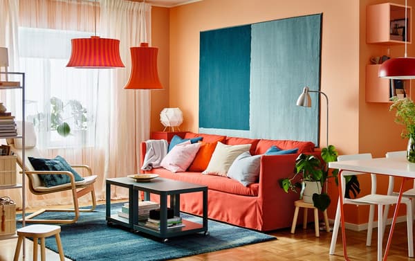 BRÅTHULT 3-seat sofa in Vissle red/orange against an orange wall and with the SÖNDERÖD rug in blue.