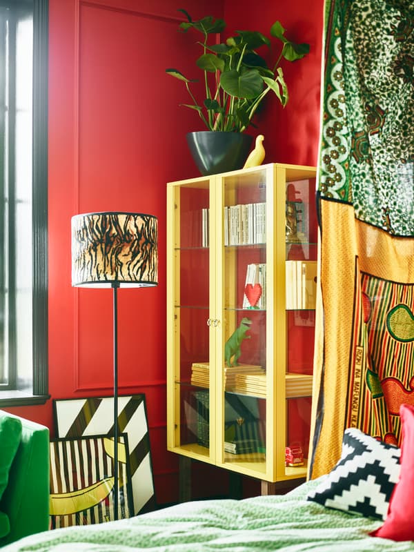 Bright coloured furniture and red walls help make this stylist’s dream bedroom.
