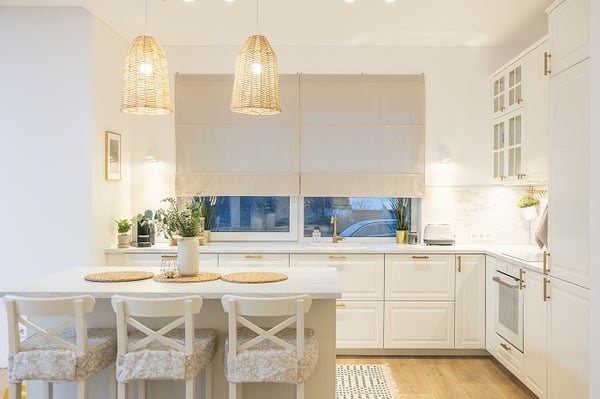 Bright Scandinavian style kitchen with kitchen island, pendant lamps, and stools.