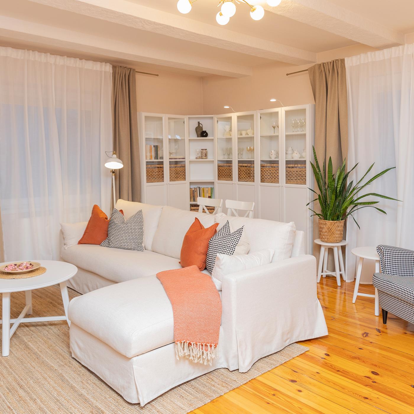 Bright Scandinavian style living room with white sofa and orange accents