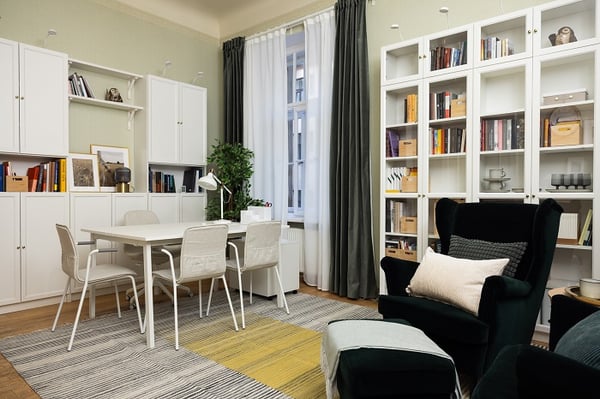 Bright study room with white shelves, worktable, chairs, and natural light