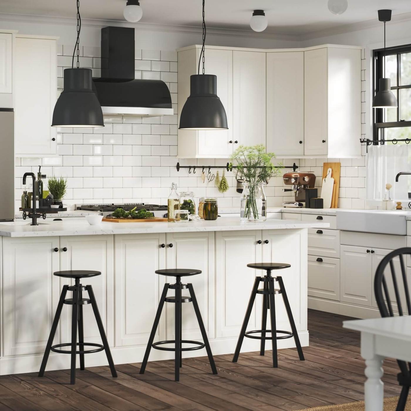 Bright white kitchen with shaker cabinets, large island, black accents and stainless appliances.