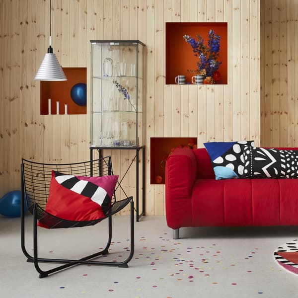 Brightly coloured and patterned furniture in a wood-panelled room.