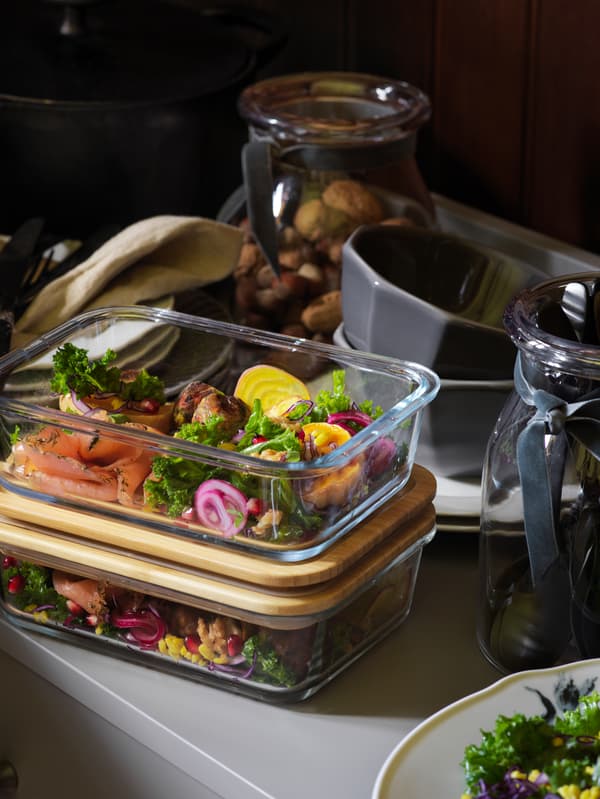 Brightly-coloured vegetables and salmon leftovers are piled into two IKEA 365+ containers with bamboo lids.