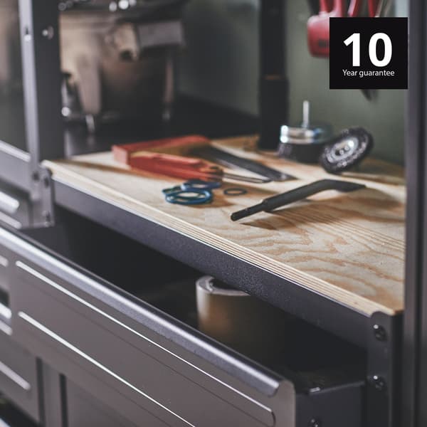 BROR heavy duty shelving with 10-year guarantee amd a wooden worktop displaying several tools on top of a builtin drawer. 